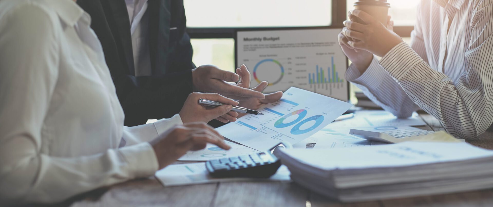 Eine Person wertet manuell Graphen und Diagramme auf ausgedrucktem Papier aus